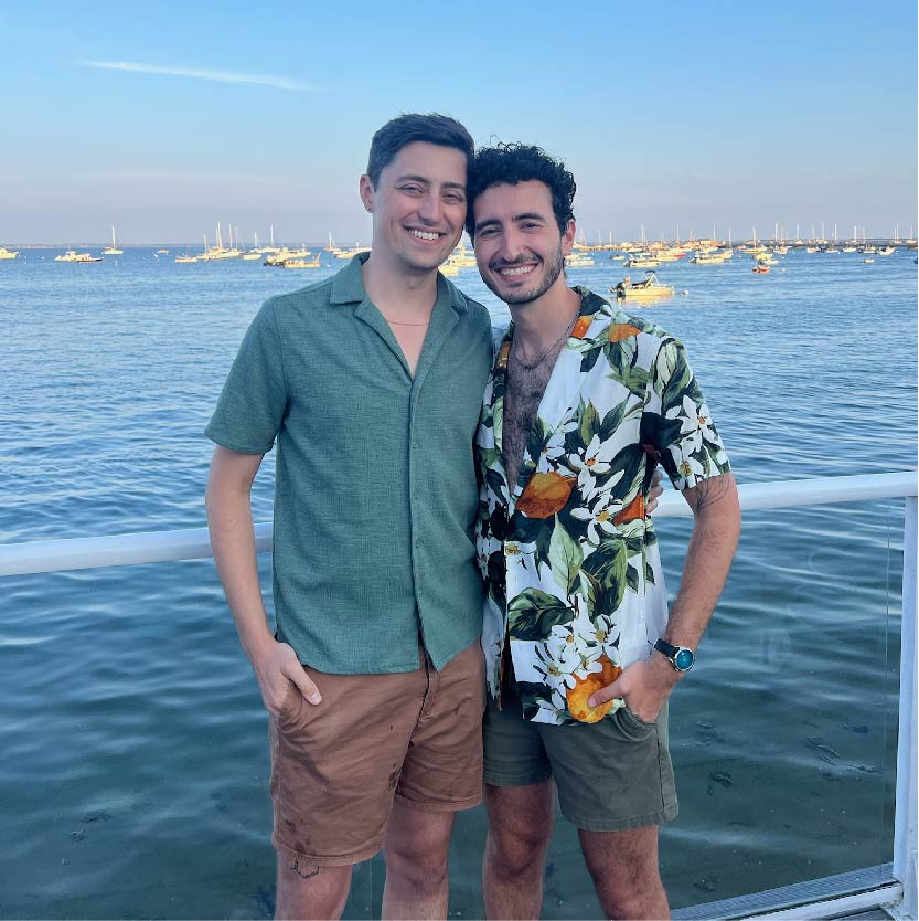 Darius and Tom posing in front of a harbor